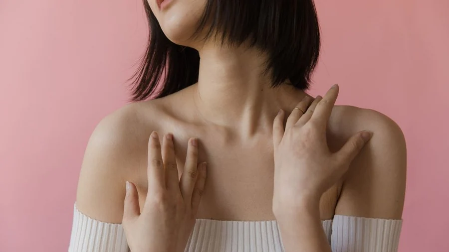 어깨 앞쪽에 두 손을 얹어 통증 위치를 확인하는 모습